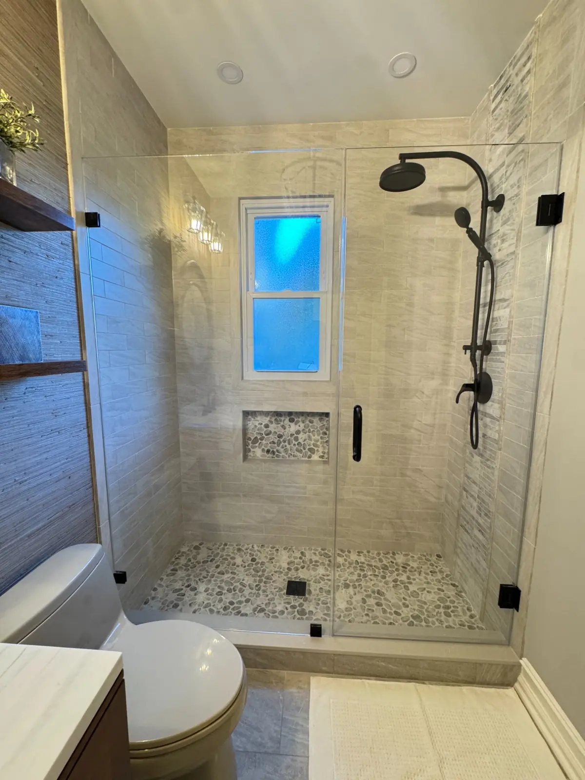 Remodelled bathroom with a tiled shower and dark fixtures